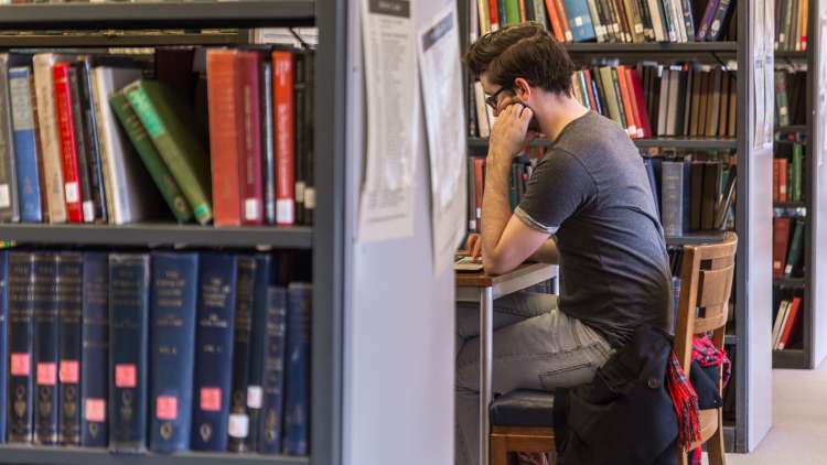 Student using laptop in Senate House Library study space