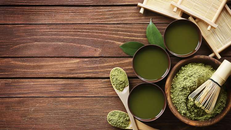 Green food in bowls on wooden boards