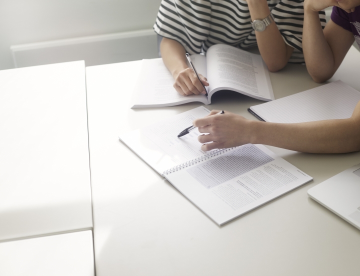 Meeting of students sitting around a table in writting